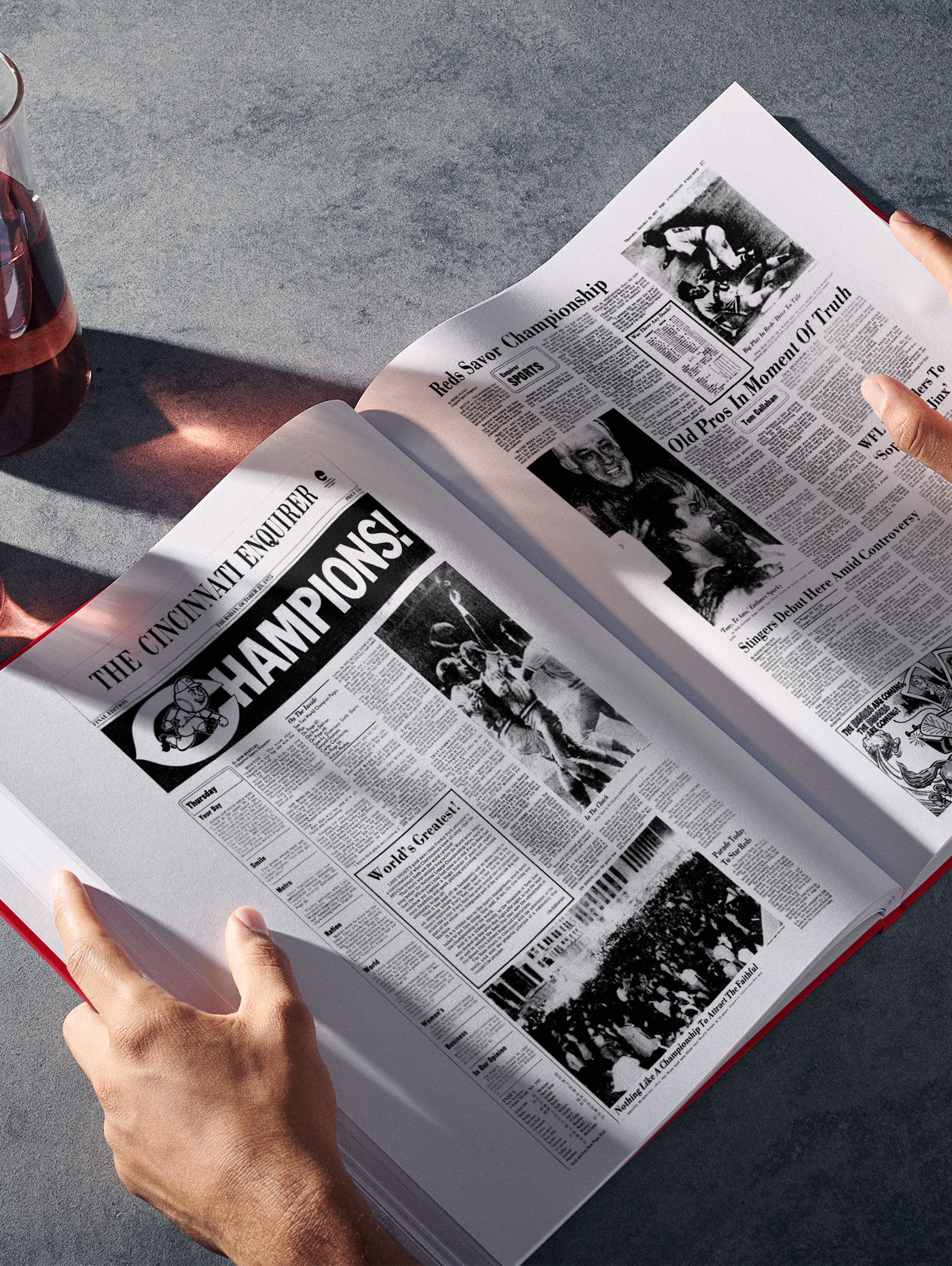 Open paperback book titled "The Baseball History of Cincinnati Reds" by Historic Newspapers, featuring vintage Reds baseball images and articles.